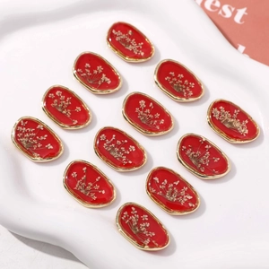 Set di pendenti ovali in resina rossa con fiori secchi e cornice dorata su vassoio bianco