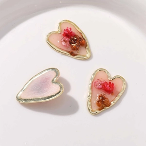 Détails de breloques en forme de cœur avec fleurs séchées incrustées et bordure dorée