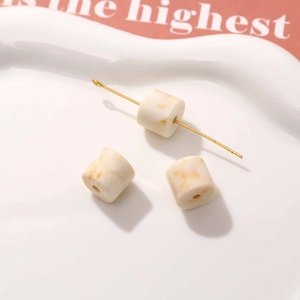 Macro shot of cylindrical resin beads with marble pattern for DIY earring jewelry making