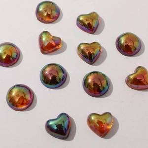 Macro view of geometric heart and round resin charms with iridescent rainbow plating