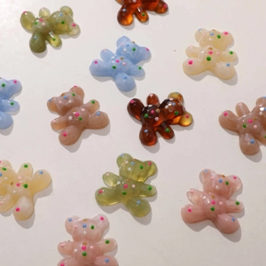Detailed close-up of colorful resin bear charms with polka dots for DIY hair accessories