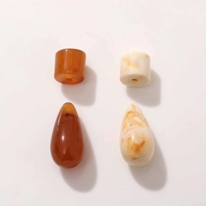 Macro shot of amber and cream resin drop charms for DIY jewelry making accessories