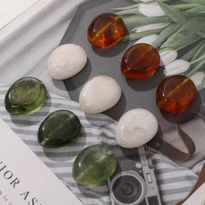 Detail of marble pattern resin beads in amber, white and green for DIY jewelry making