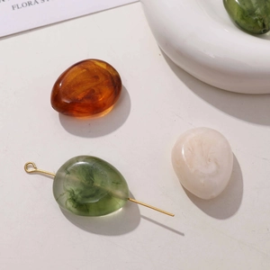 Detail of marble pattern resin beads in amber and green for DIY jewelry making