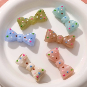 Détail de six nœuds en résine colorée à pois avec trous pour la création de bijoux DIY