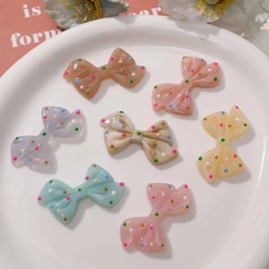Close-up of colorful polka dot resin bow accessories for DIY hair clips and phone cases