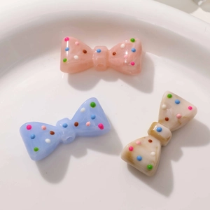 Détail de nœuds en résine avec texture marbrée et pois colorés pour accessoires