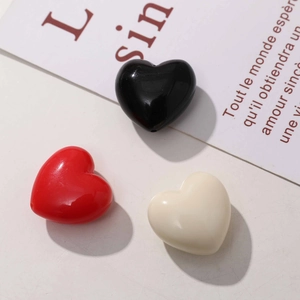 Détail de breloques en forme de cœur en résine rouge, noire et blanche pour bijoux DIY