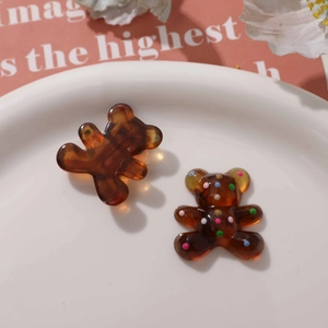 Close-up of cute amber resin bear charms with colorful polka dots for DIY jewelry