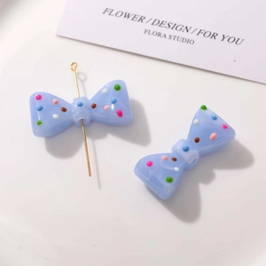 Détail du nœud en résine bleu clair avec pois colorés pour la création de bijoux DIY