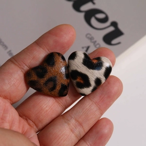 Macro detail of heart-shaped leopard print buttons for DIY jewelry making accessories