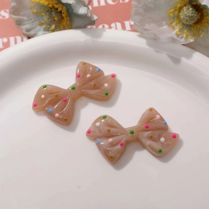 Close-up of cute colorful polka dot resin bows for DIY phone case and crafts