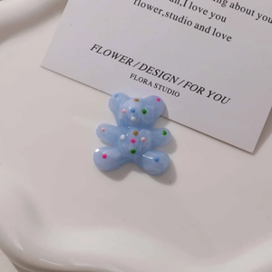 Detail of light blue resin bear charm with colorful polka dots for DIY jewelry making