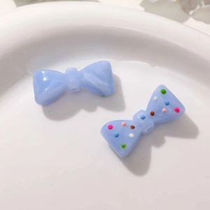 Détail macro de perles nœuds en résine bleue avec pois colorés pour bijoux DIY