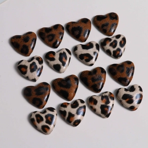 Flat lay of leopard print heart charms in brown and beige for DIY jewelry crafts