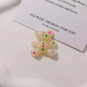 Close-up of a resin cartoon bear patch with colorful polka dots for DIY jewelry making