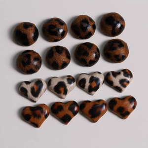 Close-up of leopard print heart and round resin buttons for DIY jewelry making