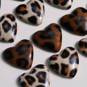 Close-up of heart-shaped leopard print charms for DIY jewelry and hair accessories