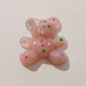 Close-up of pink translucent resin bear charm with colorful polka dots for DIY jewelry