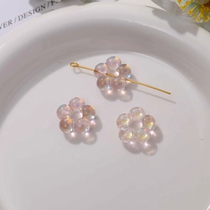 Vue détaillée de perles fleurs irisées sur tige dorée pour la création de bijoux DIY