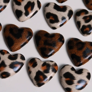 Macro detail of heart-shaped leopard print leopard fabric patches for DIY craft making