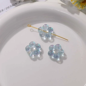 Vue macro de perles fleurs en cristal iridescent à cinq pétales pour bijoux DIY