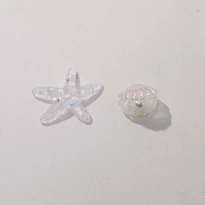 Close-up of iridescent resin starfish and shell charms with pearls for DIY crafts