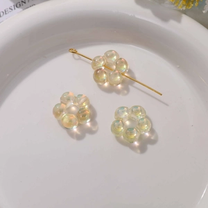 Vue macro de perles fleurs irisées en acrylique pour bijoux DIY avec trou central