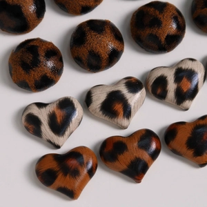 Macro shot of geometric round and heart leopard print fabric buttons for DIY accessories