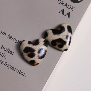 Detailed close-up of heart-shaped leopard print charms with a polished finish for DIY jewelry