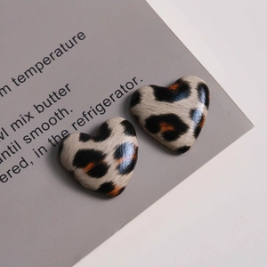 Macro detail of heart-shaped faux leather leopard print charms for DIY jewelry accessories