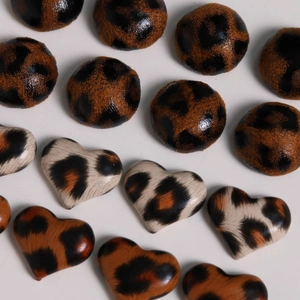 Flat lay of leopard print geometric round and heart shape buttons for DIY accessories
