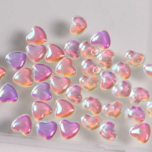 Macro detail of iridescent heart-shaped glass beads with aurora shimmer for DIY crafts