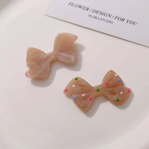 Detail of resin bow accessories with marble texture and colorful polka dot patterns