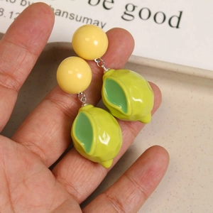 Close-up of 3D resin lemon earrings with vibrant yellow beads and green fruit pendants