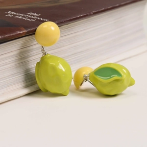 Detail of 3D lemon resin earrings with realistic texture and vibrant yellow and green tones