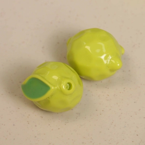 Macro shot of 3D green resin lemon charms with faceted texture and leaf for DIY jewelry