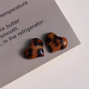 Macro shot of heart-shaped leopard print resin charms for DIY earring accessories