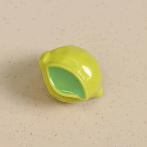 Macro shot of 3D green resin lemon charm with pre-drilled hole for DIY jewelry making