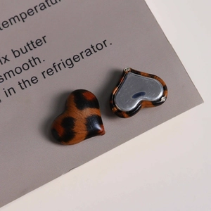 Detailed macro view of heart-shaped leopard print charms with flat silver metal back