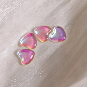 Macro shot of iridescent heart-shaped resin charms with aurora effects for nail art DIY