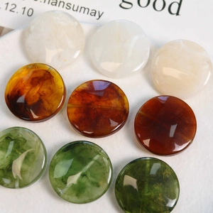 Close-up of marble pattern resin beads in amber and green for DIY bracelet making