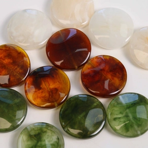 Detail of vintage smoke-textured geometric resin beads in marble and amber colors
