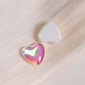 Macro shot of iridescent and white heart-shaped glass charms for DIY crafts and nail art