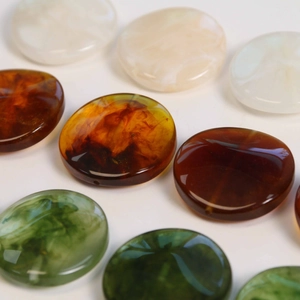 Macro detail of geometric resin beads with amber smoke texture and side hole for DIY