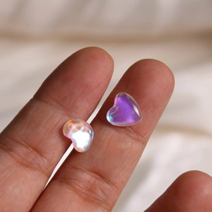 Macro detail of two iridescent heart-shaped glass stones for DIY nail art and jewelry