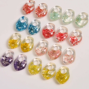 Macro detail of transparent resin teardrop pendants with colorful dried flowers