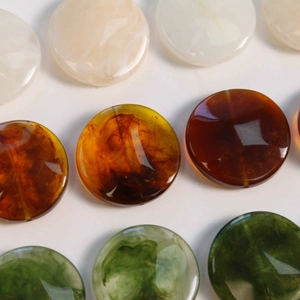 Macro shot of geometric resin beads with marble texture and amber smoke patterns