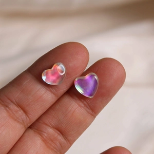 Macro shot of iridescent heart-shaped resin charms showing aurora visual effects