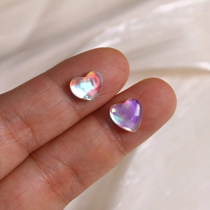 Macro shot of iridescent heart-shaped glass charms with aurora coating for DIY jewelry